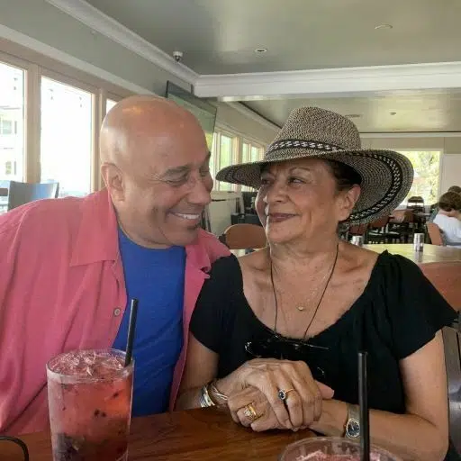 A man and woman sitting at a table with drinks.