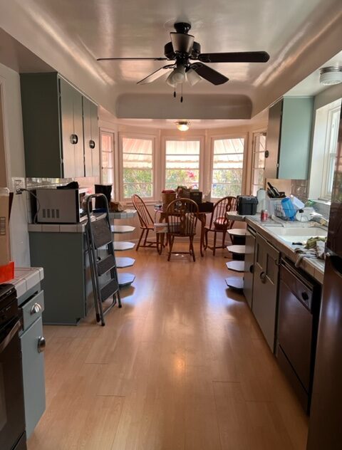 A kitchen with many windows and chairs in it