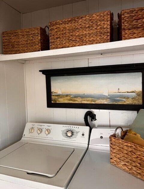 A picture of the ocean is hanging above the washer.