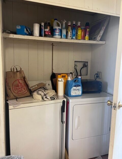 A small laundry room with two machines and shelves.
