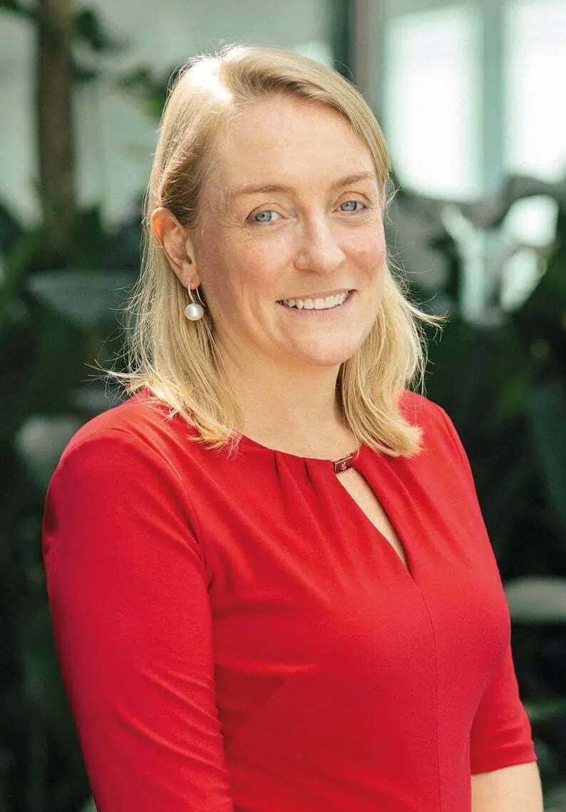 A woman in red shirt smiling for the camera.
